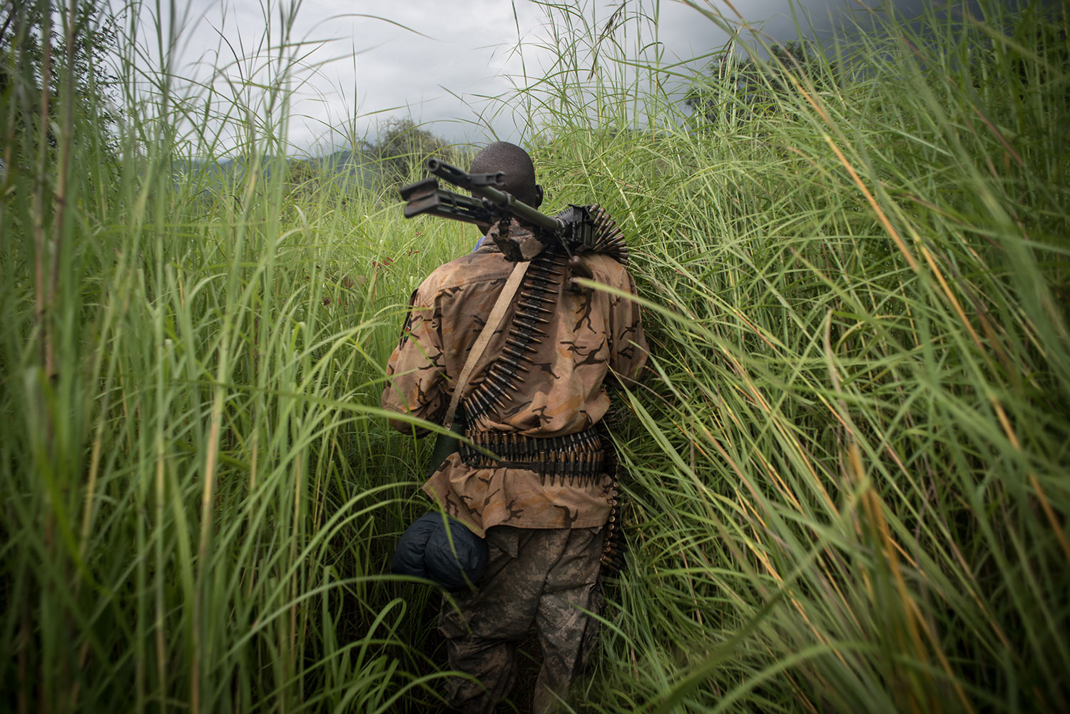 A SPLA-In Opposition soldier walks through the elephant grass in rebel-held Magwi county of South Sudan’s Eastern Equatoria state on August 28, 2017. USHMM/Jason Patinkin.