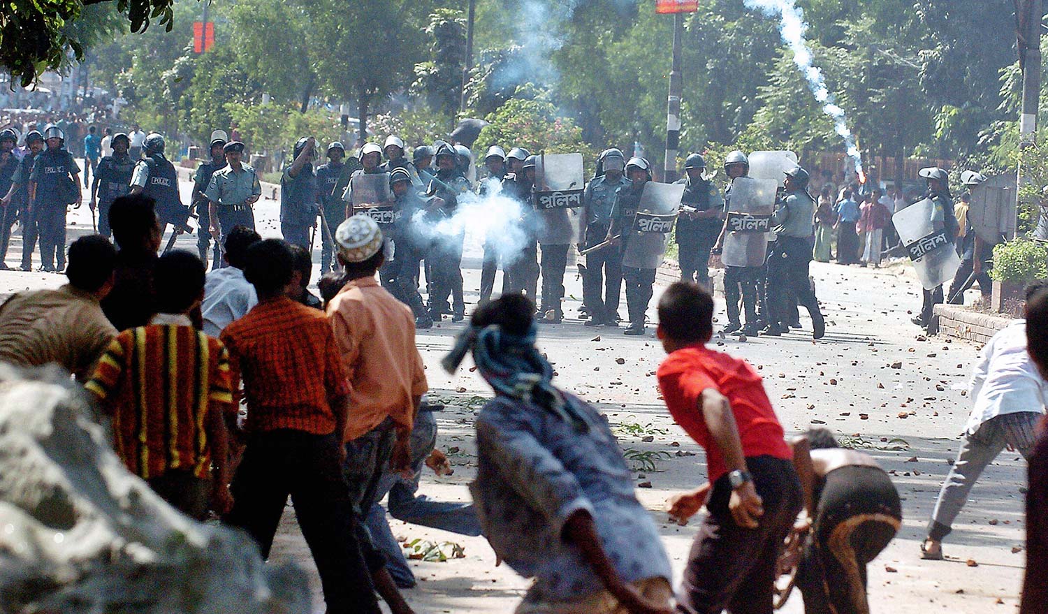 Bangladeshi policemen fire tear gas. Getty Images/Farjana K. Godhuly.